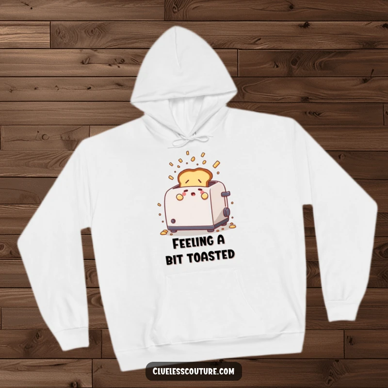 Funny hoodie with a nervous piece of toast popping out of a toaster amidst flying crumbs, offering warmth and a humorous breakfast theme.