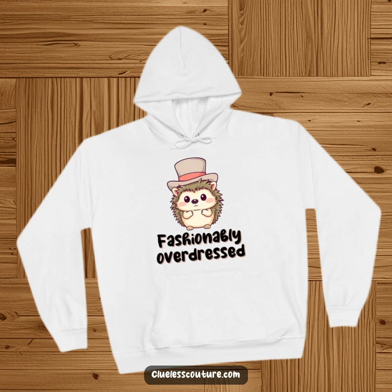 Funny hoodie showcasing a shy hedgehog comically trying to wear a gigantic top hat, perfect for cozying up.