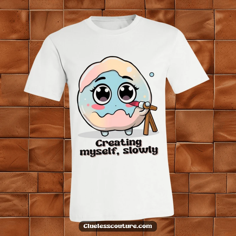 Funny t-shirt graphic of a paint blob with googly eyes hilariously trying to paint itself, depicting an artistic dilemma.
