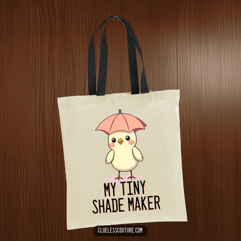 Funny tote bag featuring a bird with a tiny umbrella on its head as a hat, under the sun.